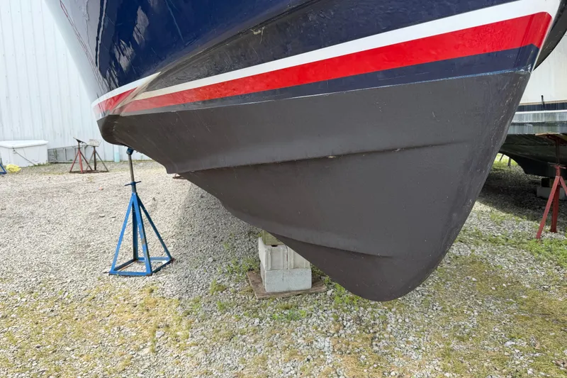 Slide: The Image of 1998 Sabreline 36 Fast Trawler hull on stands, gravel ground, side view. - 3