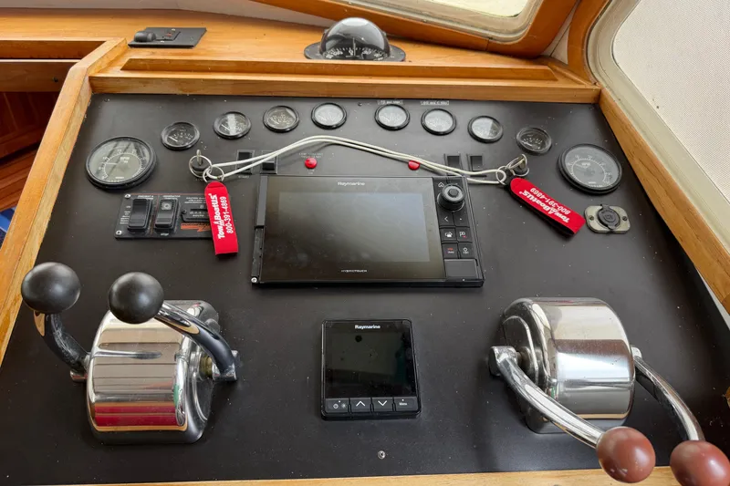 Slide: The Image of Control panel of a 1998 Sabreline 36 Fast Trawler with navigation instruments and throttle levers. - 24