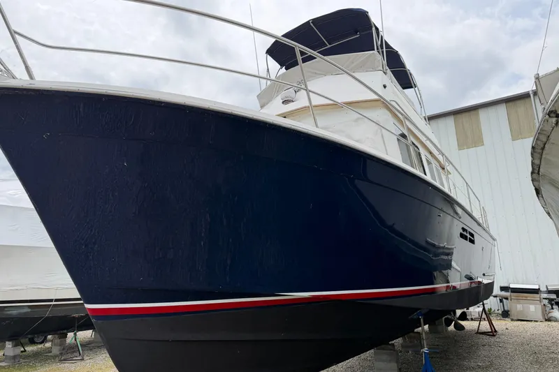 Slide: The Image of 1998 Sabreline 36 Fast Trawler with blue hull, docked in a marina. - 11