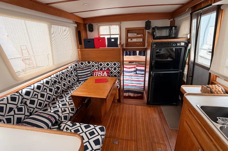 Slide: The Image of Interior of 1998 Sabreline 36 Fast Trawler with patterned seating and compact kitchen area. - 18