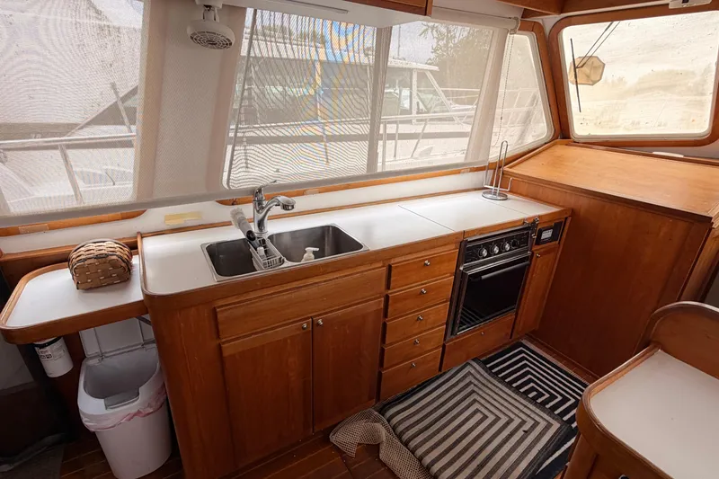 Slide: The Image of 1998 Sabreline 36 Fast Trawler kitchen with wood cabinetry, sink, and stove. - 21