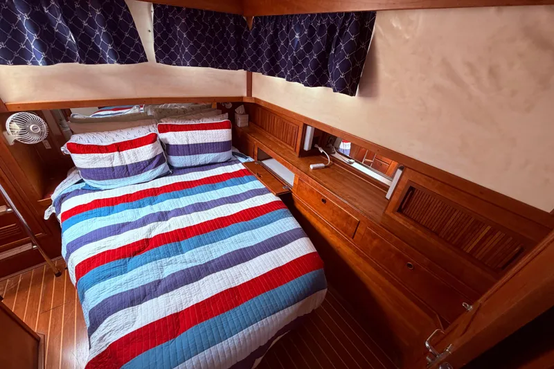 Slide: The Image of Cozy cabin interior of 1998 Sabreline 36 Fast Trawler with striped bedding and wooden furnishings. - 29