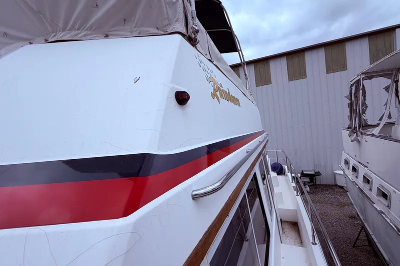 Slide: The Image of 1998 Sabreline 36 Fast Trawler docked, featuring red and black stripe detailing. - 17