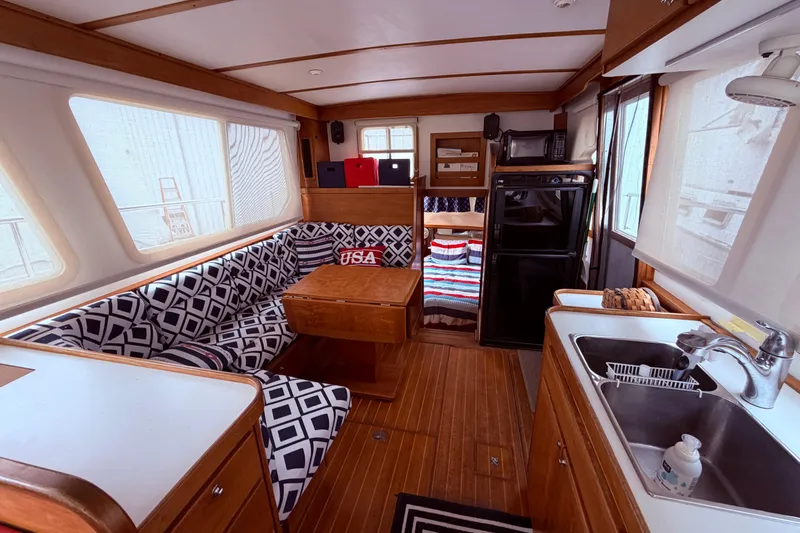 Slide: The Image of Interior of 1998 Sabreline 36 Fast Trawler with cozy seating, kitchenette, and nautical decor. - 19