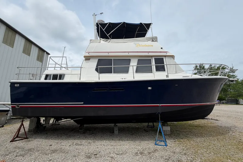 Slide: The Image of 1998 Sabreline 36 Fast Trawler with blue hull, docked on land. - 45