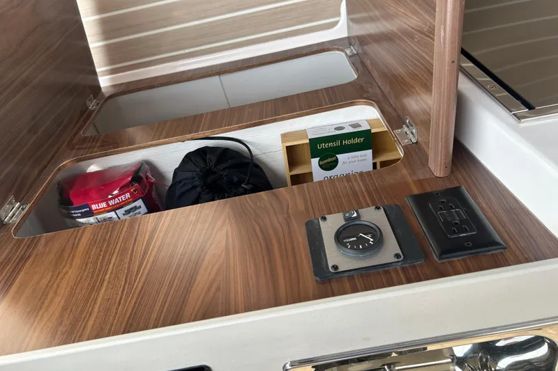 Slide: The Image of Interior storage compartment of 2027 Solara S-250 Coupe with wooden finish and accessories. - 19