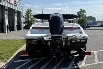 Slide: The Image of 2024 Tahoe T18 boat parked outdoors, rear view with motor, near a building. - 8