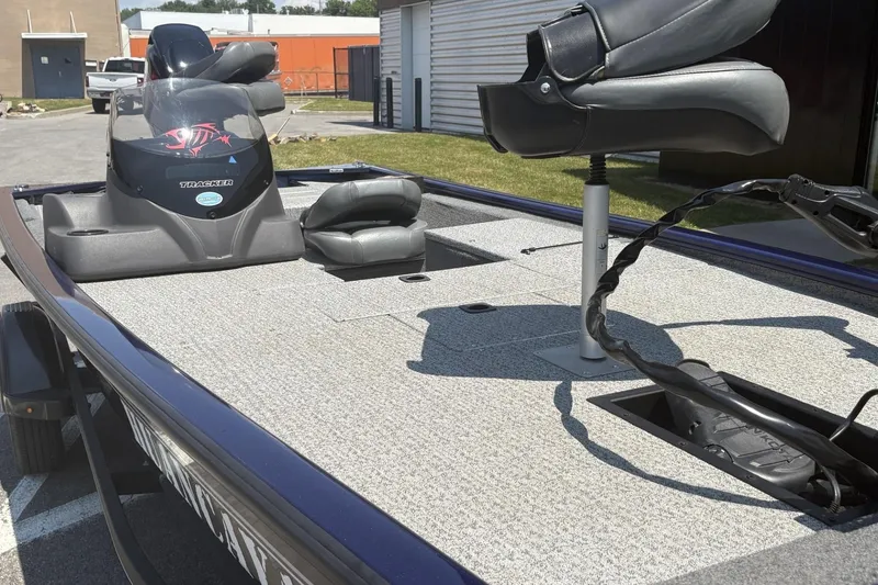 Slide: The Image of 2020 Tracker Pro 170 boat interior with seating and control panel, parked outdoors. - 5