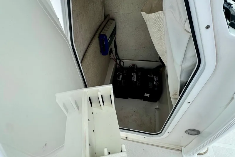 Slide: The Image of 2015 Sea Hunt Ultra 234 boat storage compartment with batteries and equipment. - 13