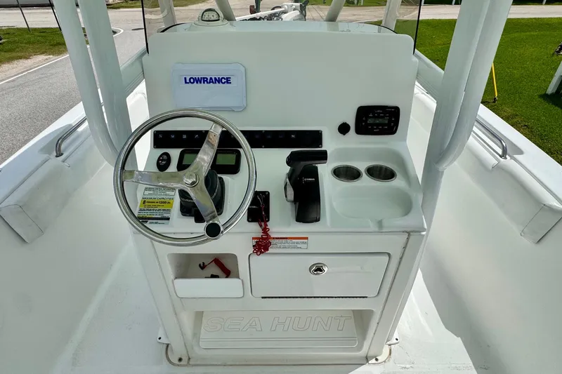 Slide: The Image of Center console of a 2015 Sea Hunt Ultra 234 boat with steering wheel and controls. - 10