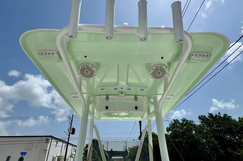 Slide: The Image of 2015 Sea Hunt Ultra 234 T-top with speakers and rod holders under clear sky. - 11