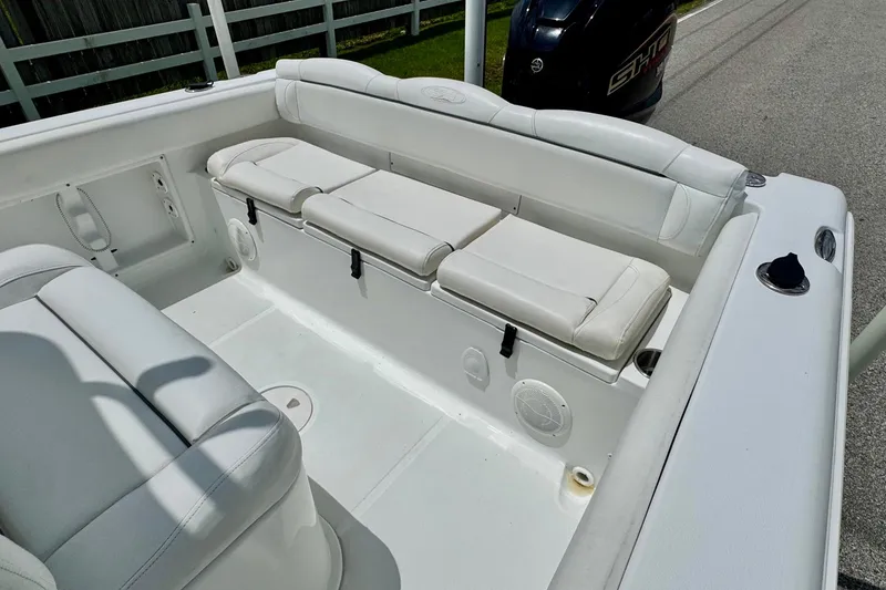 Slide: The Image of 2015 Sea Hunt Ultra 234 boat interior with white cushioned seating and storage. - 7