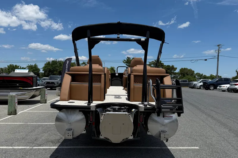 Slide: The Image of 2026 Berkshire 23RFX STS pontoon boat with tan seating, parked under a clear blue sky. - 6