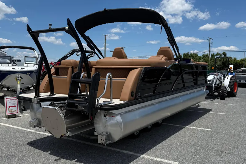 Slide: The Image of 2026 Berkshire 23RFX STS pontoon boat with tan seating, parked outdoors under a blue sky. - 7