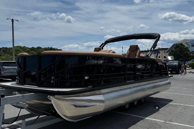 Slide: The Image of 2026 Berkshire 23RFX STS pontoon boat parked in a sunny lot, showcasing sleek design. - 3