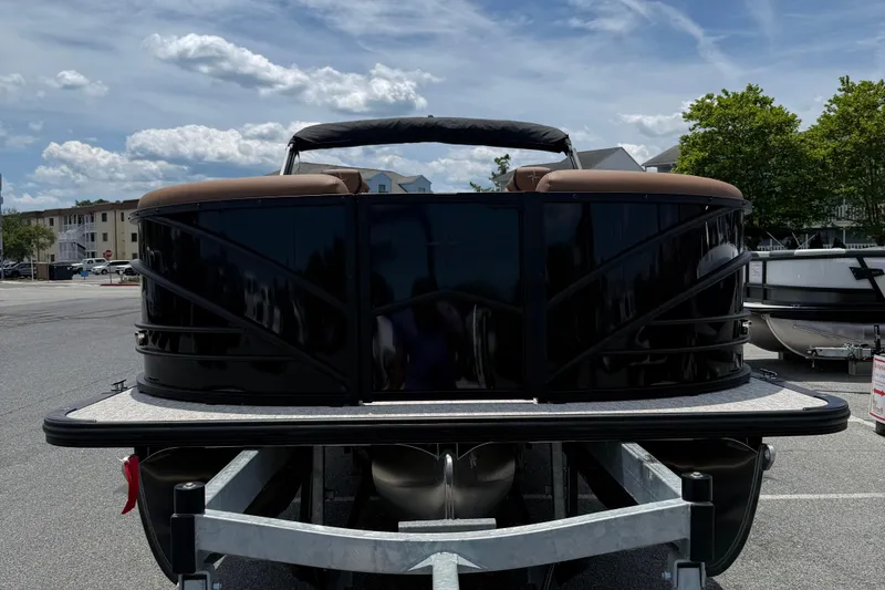 Slide: The Image of 2026 Berkshire 23RFX STS pontoon boat on trailer under a partly cloudy sky. - 2