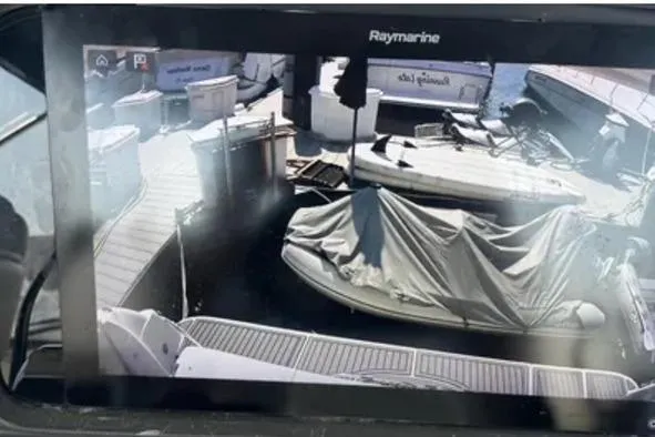 Slide: The Image of Raymarine display showing docked boats, including a covered vessel, near a 2007 Sea Ray 44 Sedan Bridge. - 18