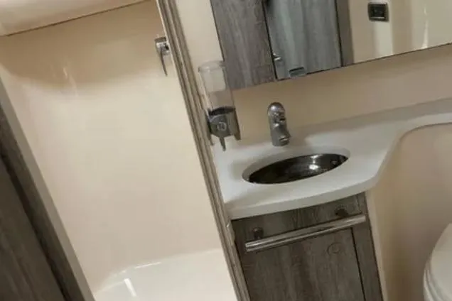 Slide: The Image of 2007 Sea Ray 44 Sedan Bridge bathroom with modern sink and cabinetry. - 23