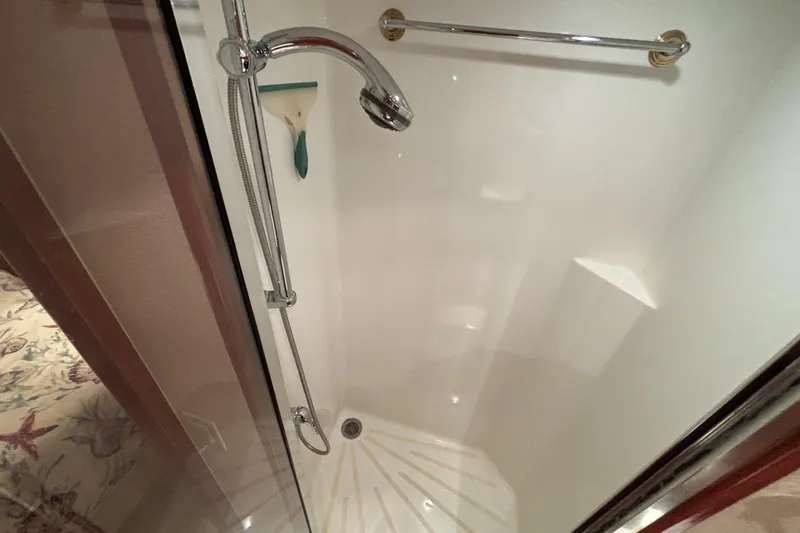 Slide: The Image of Shower area in 2005 Hatteras 50 Convertible yacht, featuring chrome fixtures and white interior. - 24
