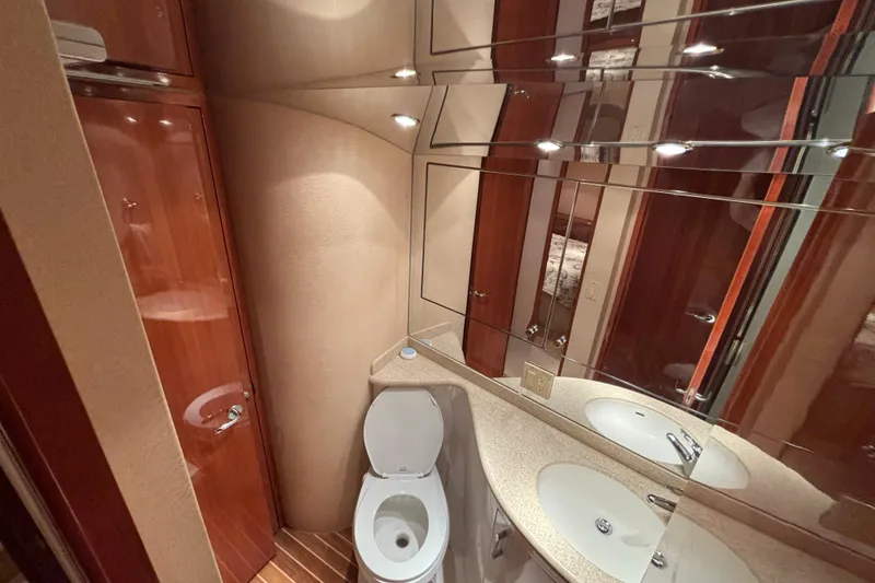 Slide: The Image of Luxurious bathroom interior of 2005 Hatteras 50 Convertible yacht with mirrored walls and wooden cabinetry. - 18