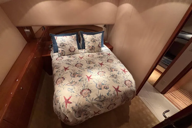 Slide: The Image of Luxurious bedroom interior of 2005 Hatteras 50 Convertible yacht with nautical-themed bedding. - 20