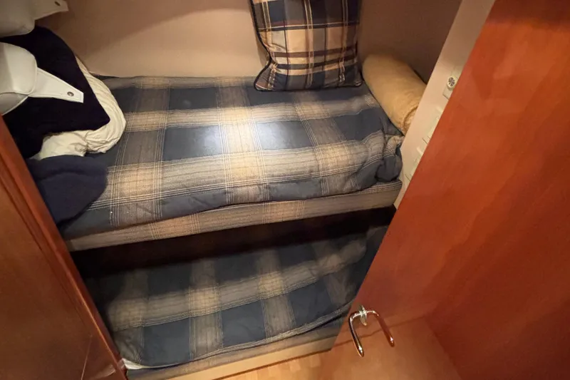 Slide: The Image of Bunk beds with plaid bedding in a 2005 Hatteras 50 Convertible yacht cabin. - 25