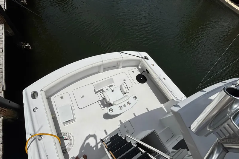 Slide: The Image of 2005 Hatteras 50 Convertible yacht deck, featuring fishing equipment and spacious layout. - 12