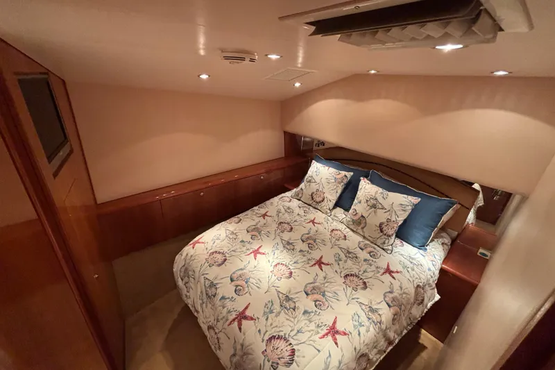 Slide: The Image of Luxurious bedroom interior of 2005 Hatteras 50 Convertible yacht with nautical-themed bedding. - 19