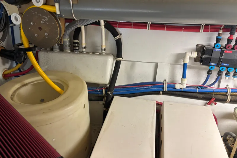 Slide: The Image of Engine room of a 2005 Hatteras 50 Convertible yacht, showcasing plumbing and wiring. - 30