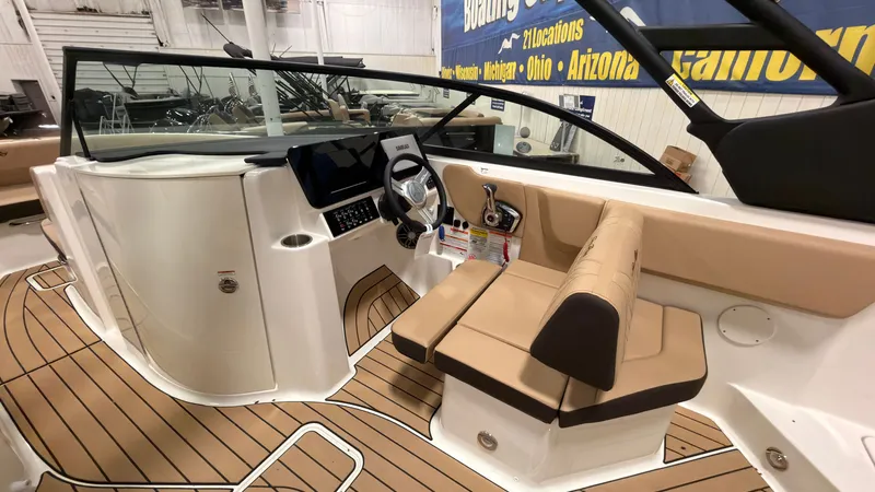 Slide: The Image of The image shows the cockpit of a 2026 Sea Ray SDX 230 with brown seating and a modern helm. - 24