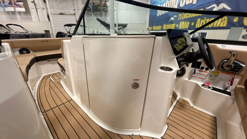 Slide: The Image of The image shows the cockpit of a Sea Ray SDX 230 boat with sleek seating and wood flooring. - 42