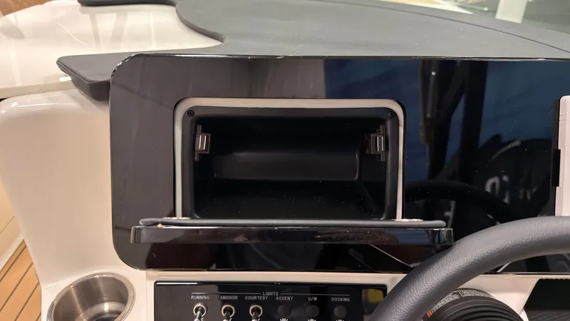 Slide: The Image of Dashboard of a 2026 Sea Ray SDX 230 with an open storage compartment. - 28