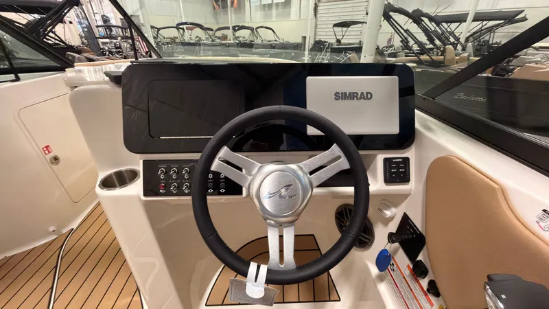 Slide: The Image of The 2026 Sea Ray SDX 230 cockpit features a modern steering wheel and a Simrad display. - 26