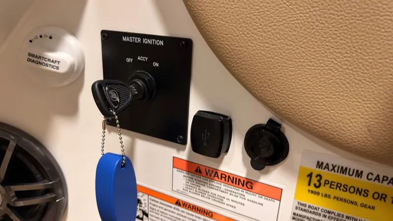 Slide: The Image of Close-up of a Sea Ray SDX 230 ignition switch with warning labels and a USB port. - 31