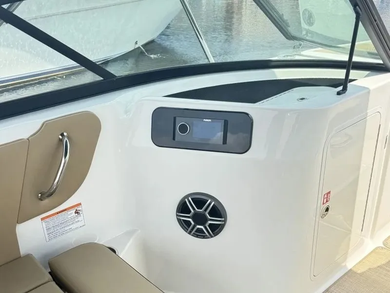 Slide: The Image of Interior view of a Sea Ray SDX 230 boat with beige seating and a speaker. - 13