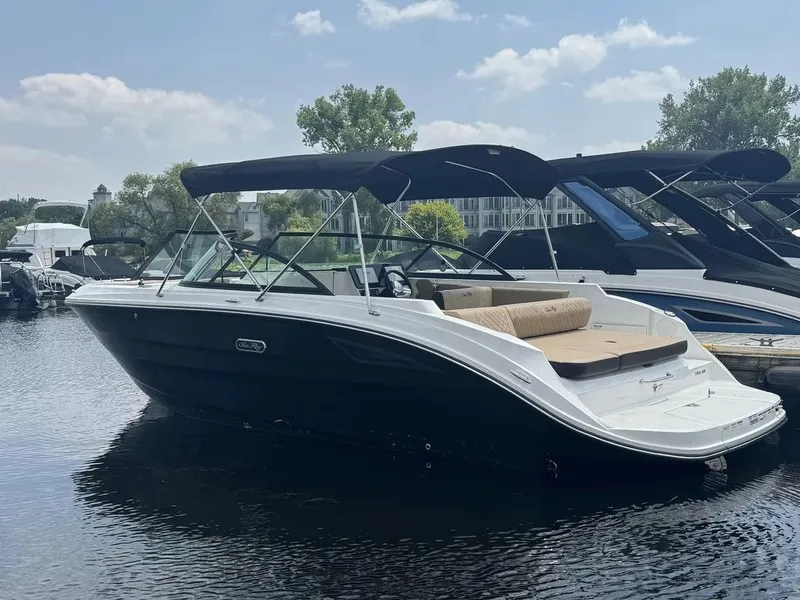 The Image of A 2026 Sea Ray SDX 230 is on the water. It features a black hull design and a sunshade. - 0