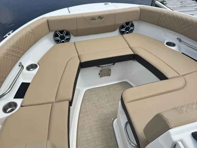 Slide: The Image of The image shows the bow area of a Sea Ray SDX 230 boat with beige cushions and speakers. - 16