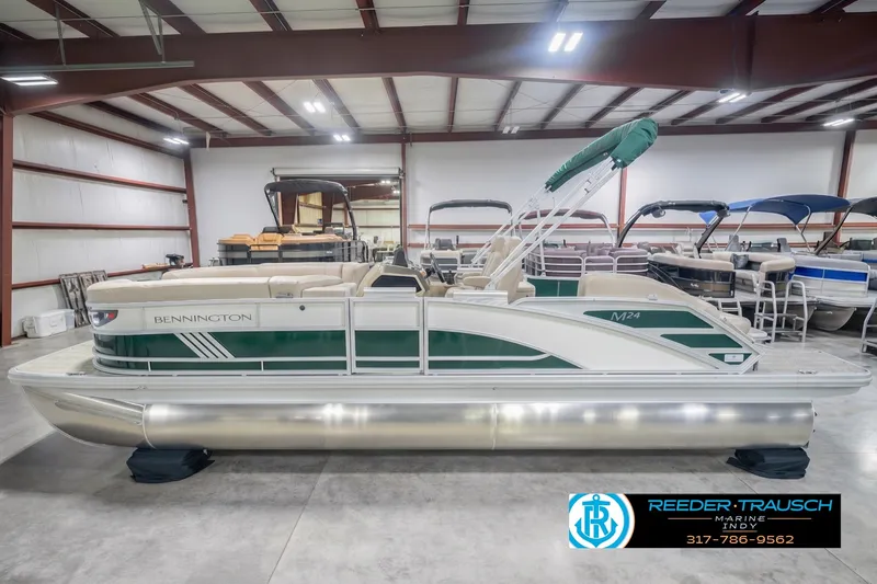 The Image of 2027 Bennington 24 MSB pontoon boat in showroom, featuring green and white design. - 0