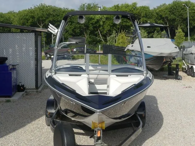 Slide: The Image of 2008 Tigé Z1 boat on a trailer, surrounded by trees and other boats. - 3