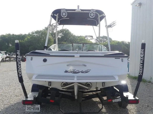 Slide: The Image of Rear view of a white 2008 Tigé Z1 boat on a trailer, featuring a tower and speakers. - 5