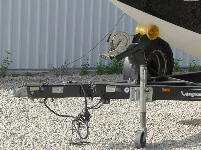 Slide: The Image of Close-up of a boat trailer with a winch and jack wheel on gravel. - 10