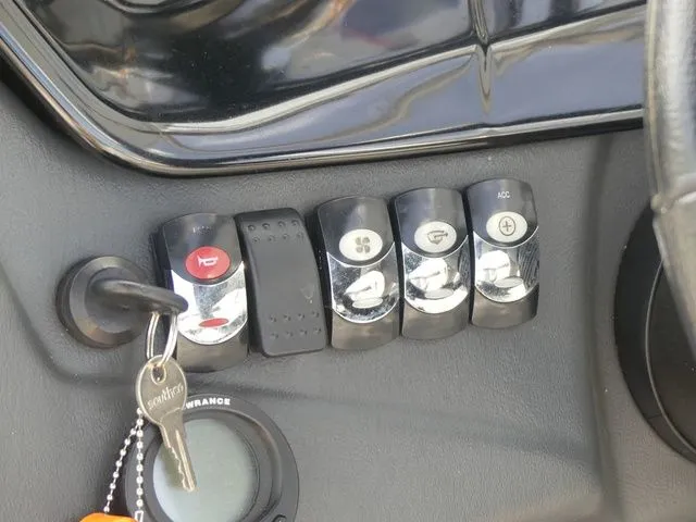 Slide: The Image of Close-up of a 2008 Tigé Z1 dashboard with switches and an ignition key. - 27
