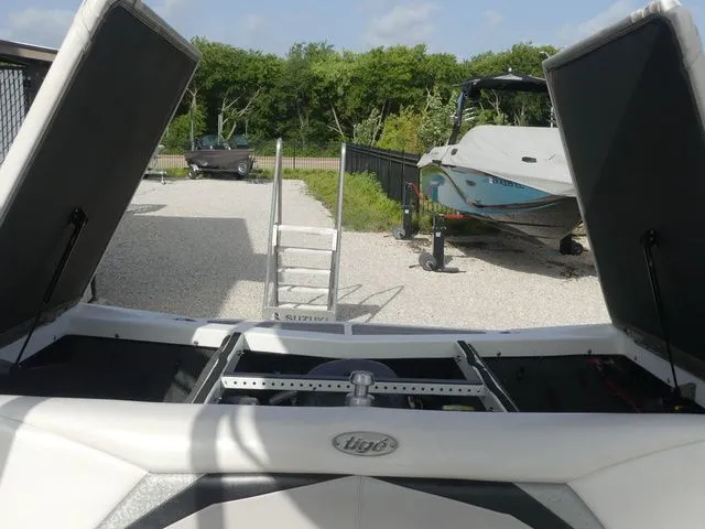 Slide: The Image of The image shows the rear of a 2008 Tigé Z1 boat with open storage compartments. - 23