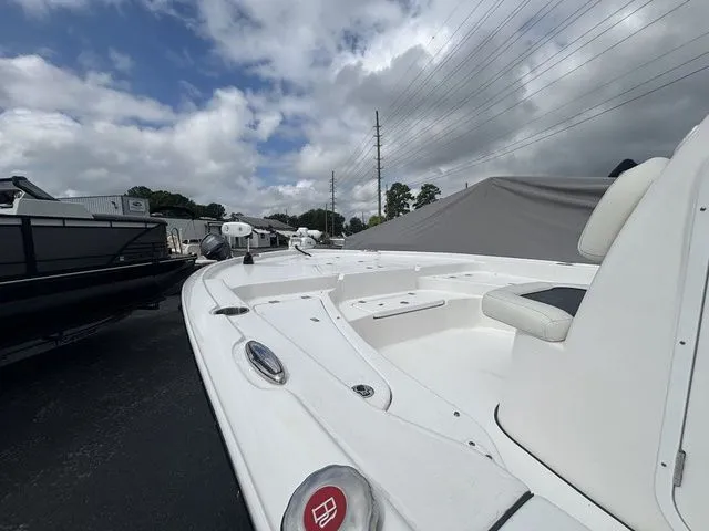 Slide: The Image of The image shows a white boat with seating and an open deck, parked in a lot. - 4