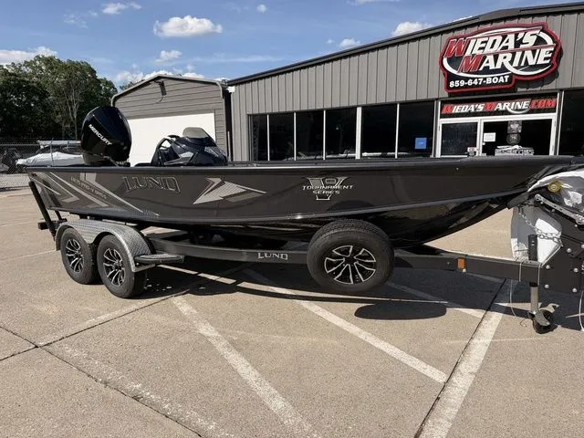 Slide: The Image of A black Lund 1875 Pro-V Bass XS boat on a trailer in front of a building. - 9