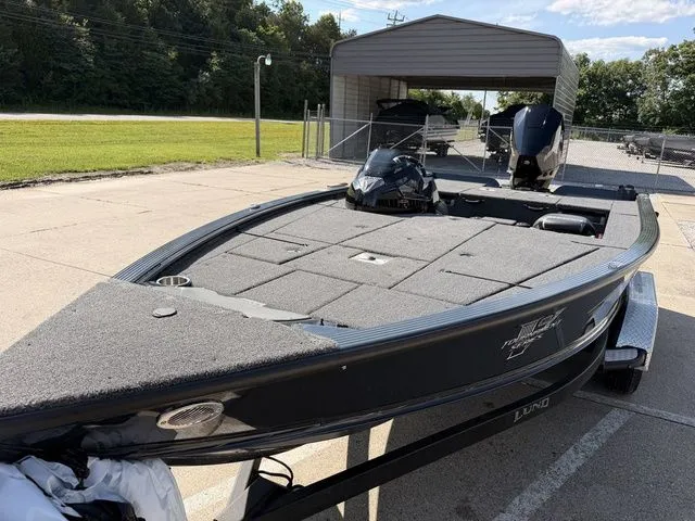 Slide: The Image of A 2026 Lund 1875 Pro-V Bass XS boat on a trailer in an outdoor area. - 10