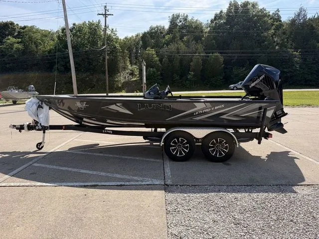 Slide: The Image of A 2026 Lund 1875 Pro-V Bass XS on a trailer, parked in a lot. - 13