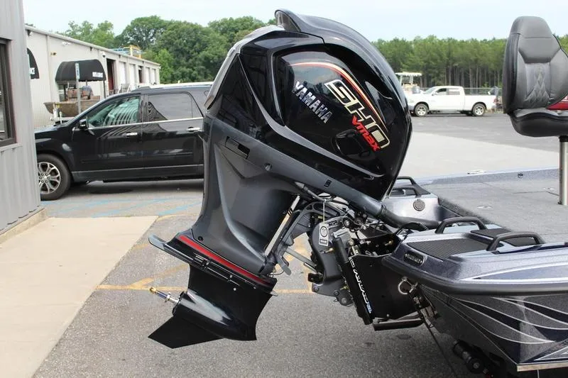 Slide: The Image of Outboard motor on a 2027 Phoenix 921 Elite X boat, parked outdoors. - 8