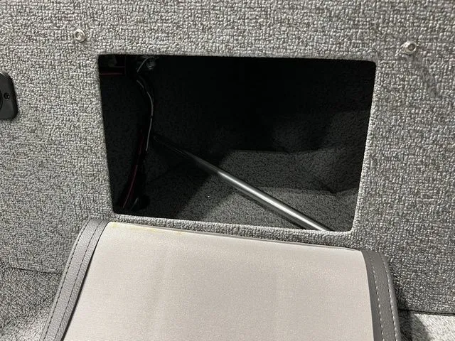 Slide: The Image of An open storage compartment with gray carpeting and a metal rod inside. - 27