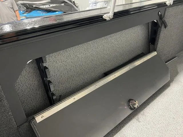Slide: The Image of Interior view of a boat with gray carpet flooring and black storage compartment. - 11